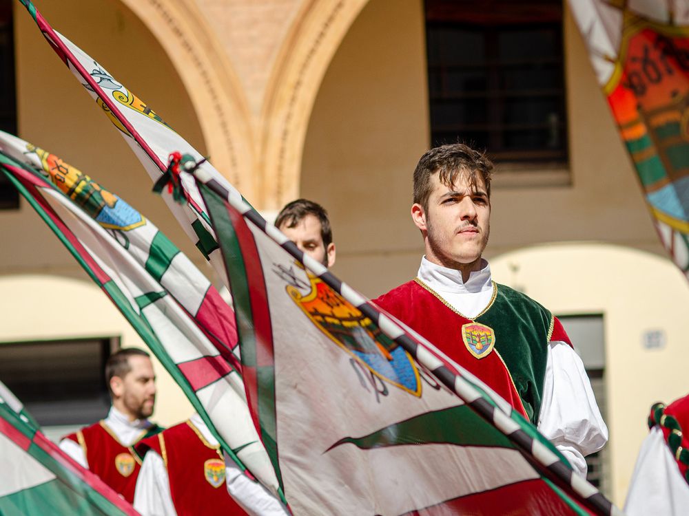 Sbandieratori del Borgo San Luca in esercizio con le bandiere rosse e verdi